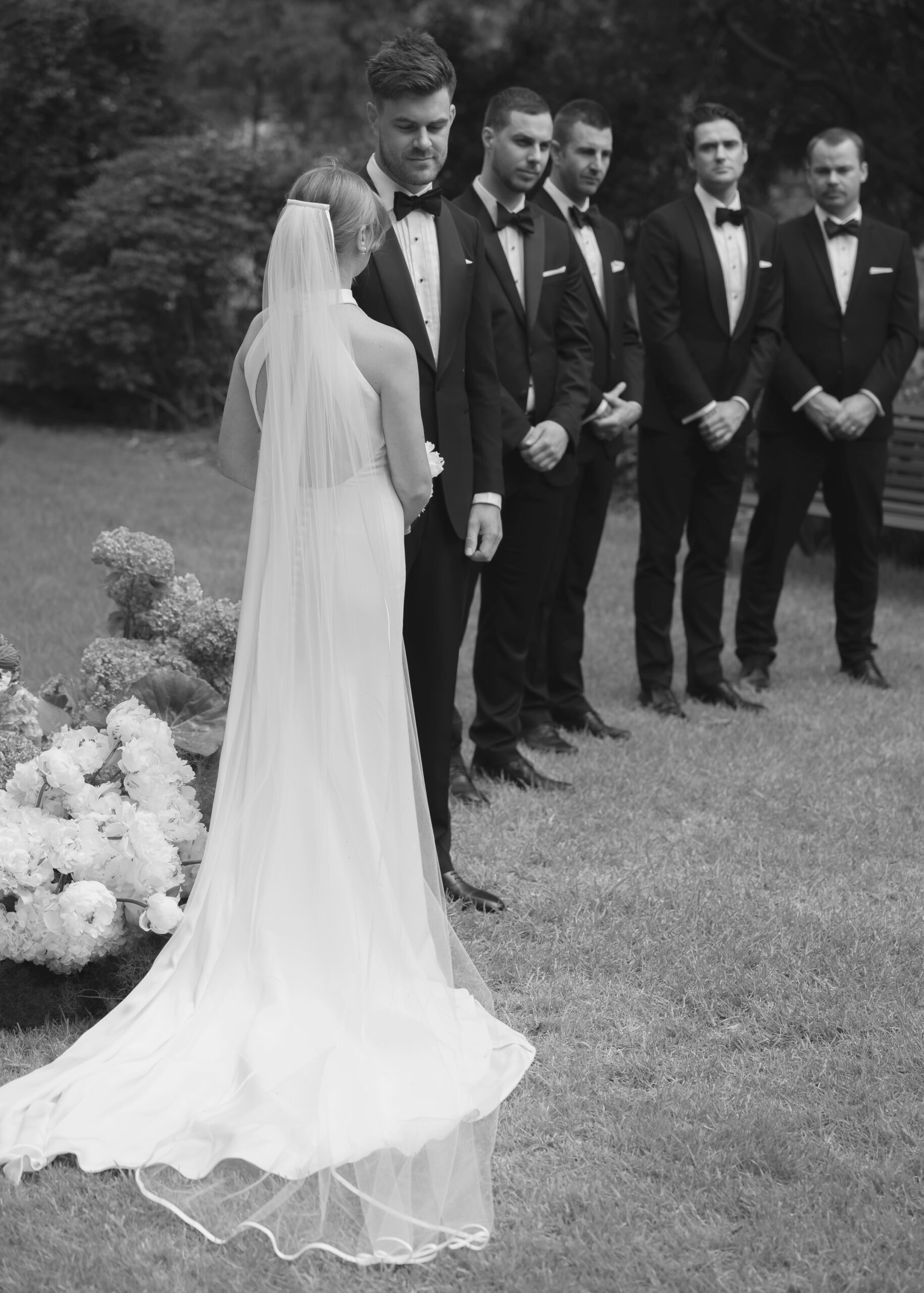 A monochrome image of Bonnie and George and their wedding party at their Burnley Gardens wedding in Melbourne